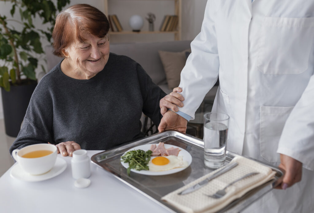 Gros plan d’une femme âgée prenant son petit-déjeuner servi sur un plateau